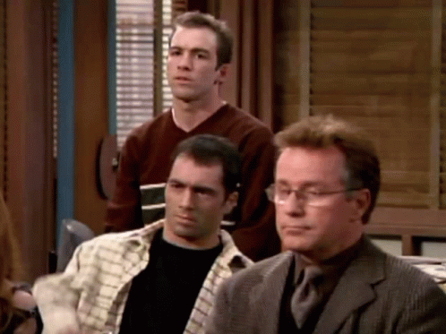Group of Men Sitting One With Glasses