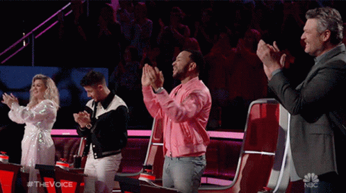 Group of People Applauding on Stage With NBC Logo