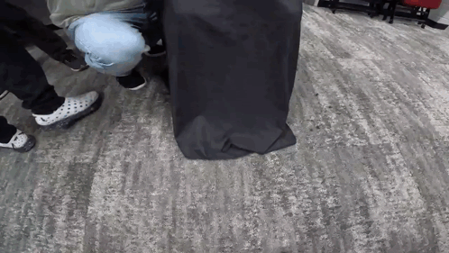 Group of People Around Black Bag