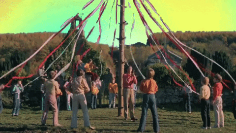 Group Of People Around Pole With Ribbons GIF