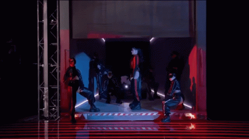 Group of People Dancing in Red-Lit Dark Room