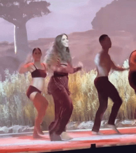 Group of People Dancing on Stage in Front of Large Screen