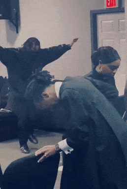 Group of People Dancing Under Red Exit Sign