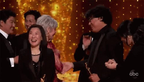 Group Of People Holding Trophies On Stage GIF