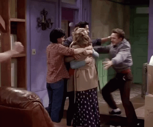Group of People Hugging in Living Room