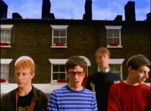 Group Of People In Front Of Brick Building GIF