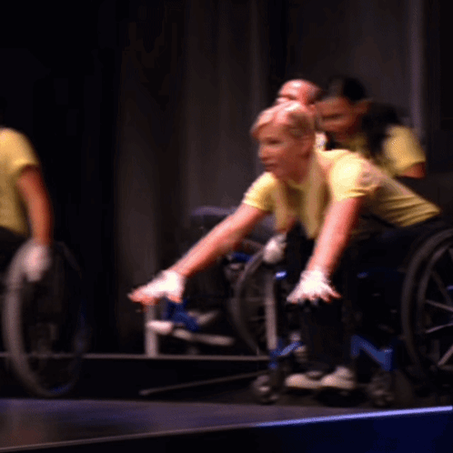 Group Of People In Wheelchairs Raising Hands GIF