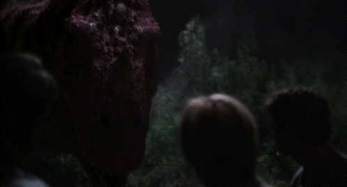 Group Of People Looking At Large Red Monster In Dark GIF