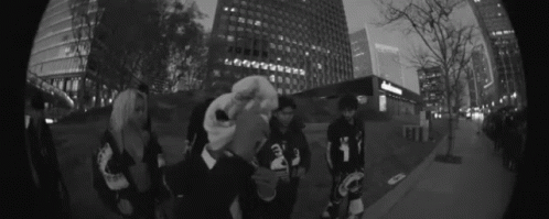 Group of People on Sidewalk in Front of Tall Buildings
