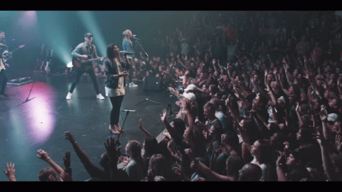 Group Of People On Stage With Hands Up GIF