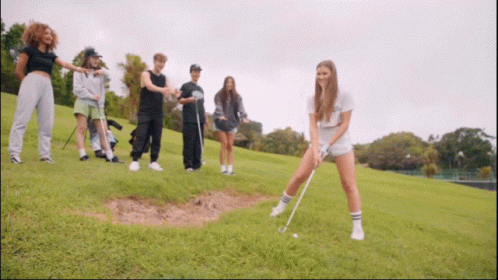 Group of People Playing Golf on Grassy Hill