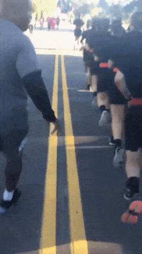 Group of People Running Down Street With Yellow Line