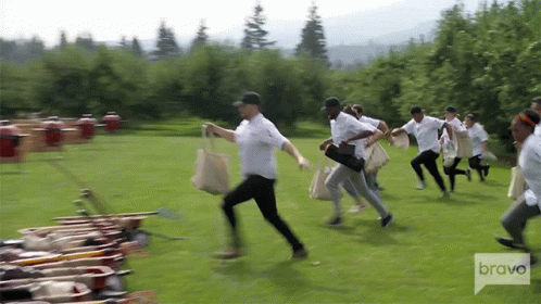 Group of People Running in Field with Bravo Logo