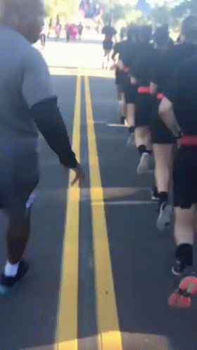 Group Of People Running On Street With Yellow Line GIF