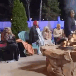 Group of People Sitting Around Fire Pit at Night