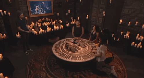 Group of People Sitting Around Table With Candles and Clock