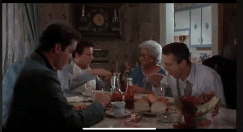 Group of People Sitting Around Table With Clock