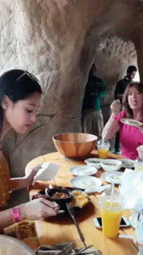 Group of People Sitting at Table With Food and Drinks