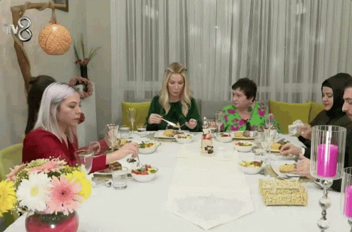 Group of People Sitting at Table with TV8