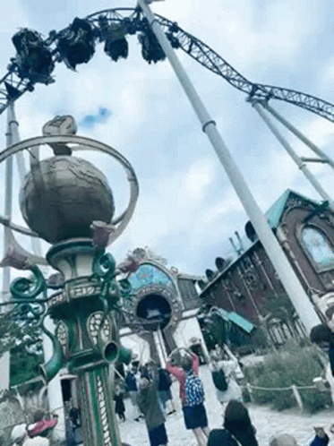 Group of People Standing in Front of a Roller Coaster