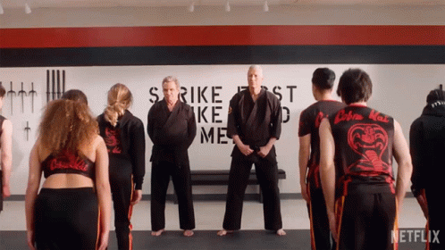 Group of People Standing in Front of Strike First Strike Me Wall