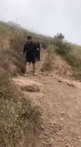 Group Of People Walking Up Dirt Path GIF