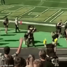 Group of People With Arms in Air on Football Field