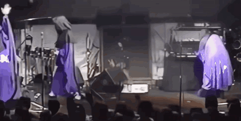 Group of People with Purple Umbrellas on Stage