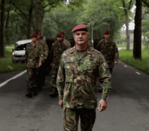 Group Of Soldiers Walking, One With Red Beret GIF