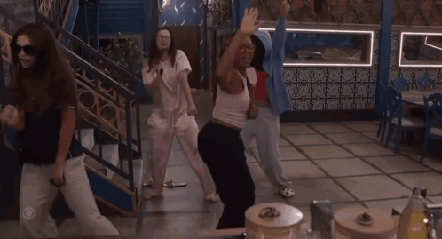 Group of Women Dancing in Room With Green Couch