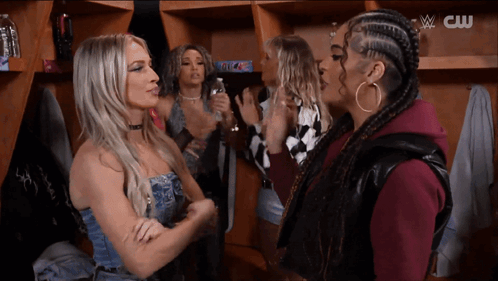 Group of Women in Locker Room With CW Logo