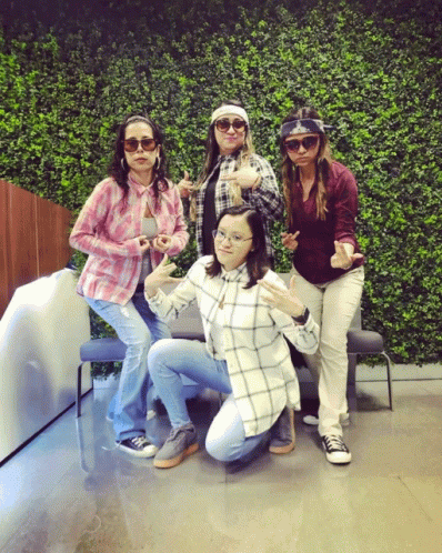 Group Of Women Posing In Front Of Hedge Wall GIF