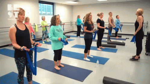 Group of Women Standing on Yoga Mats with be st Logo
