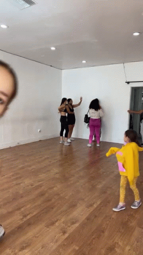 Group of Women With Little Girl in Yellow Hoodie in Dance Studio