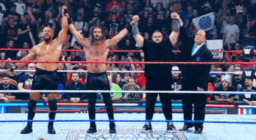 Group of Wrestlers With Hands in the Air in Ring