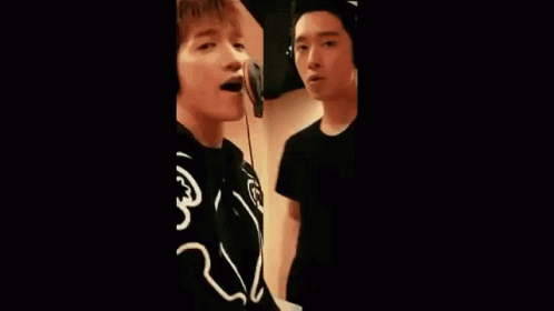 Group of Young Men Singing into Microphones
