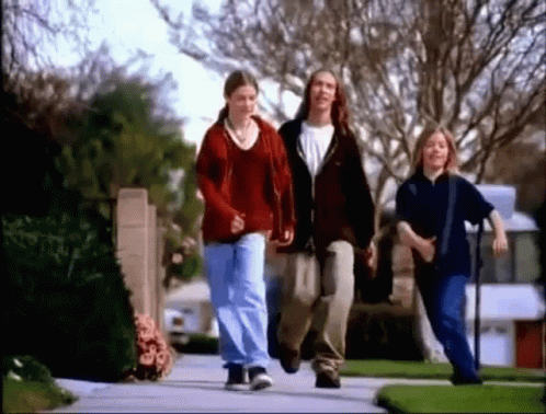 Group Of Young People Walking On Neighborhood Sidewalk GIF