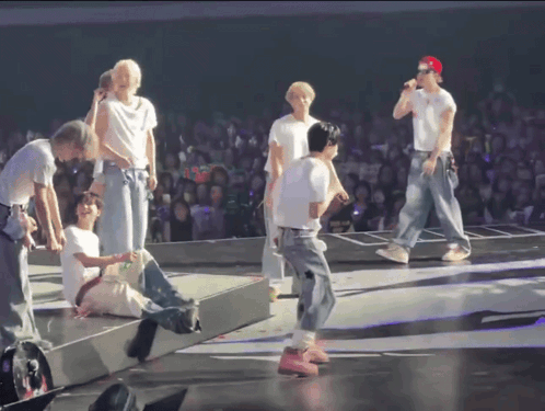 Group on Stage With Red Cap
