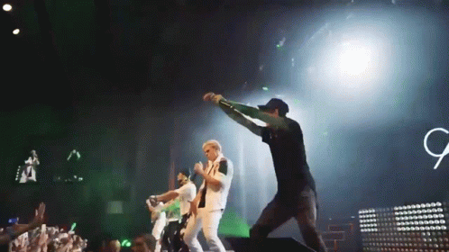 Group On Stage With Sign Saying G GIF
