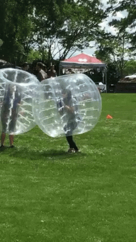 Group Playing Bubble Soccer in Grass