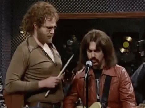 Group Playing Guitars and Singing Into Microphones