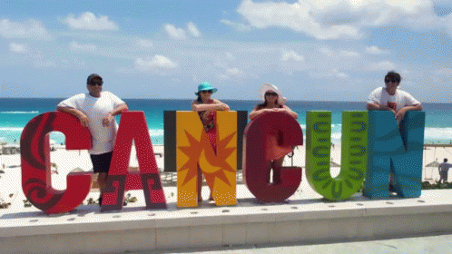 Group Posing In Front Of Cancun Sign GIF