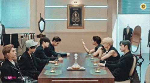 Group Sitting Around Table With Sign Saying 12