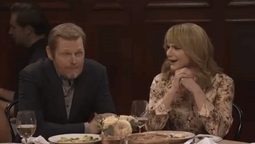Group Sitting Around Table With Wine And Plates GIF