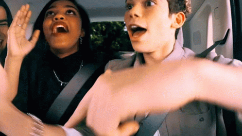 Group Sitting in Back Seat With Hands Up