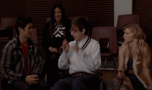 Group Sitting in Chairs One Talking on Phone