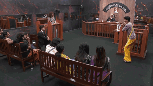 Group Sitting on Courtroom Benches With Malayalam Sign
