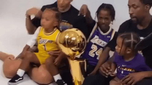 Group Sitting on Floor with Basketball Trophy