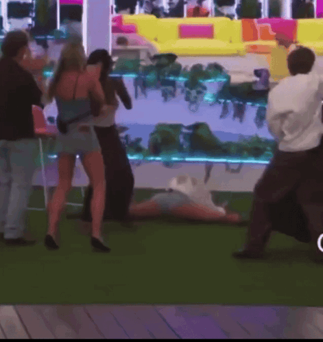 Group Standing Around Person Lying On Ground GIF