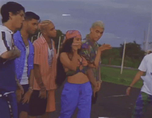 Group Standing Around Woman In Crop Top And Blue Shorts GIF